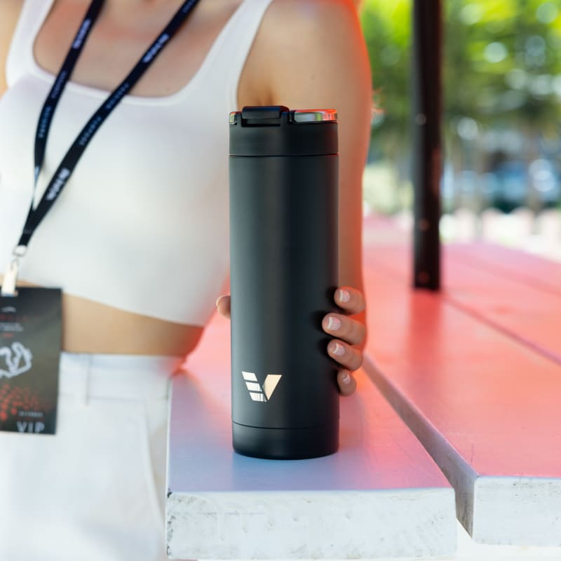 A female holding her Ever Vessel Maxi Black stainless steel water bottle at an event.