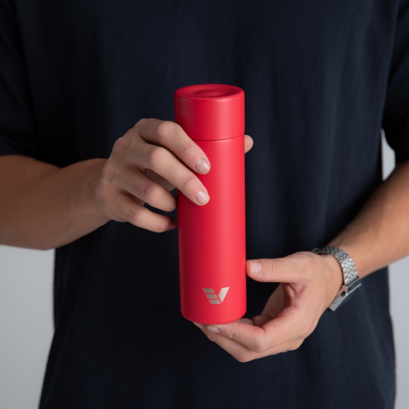 A male holding his Ever Vessel Mini Red small water bottle.