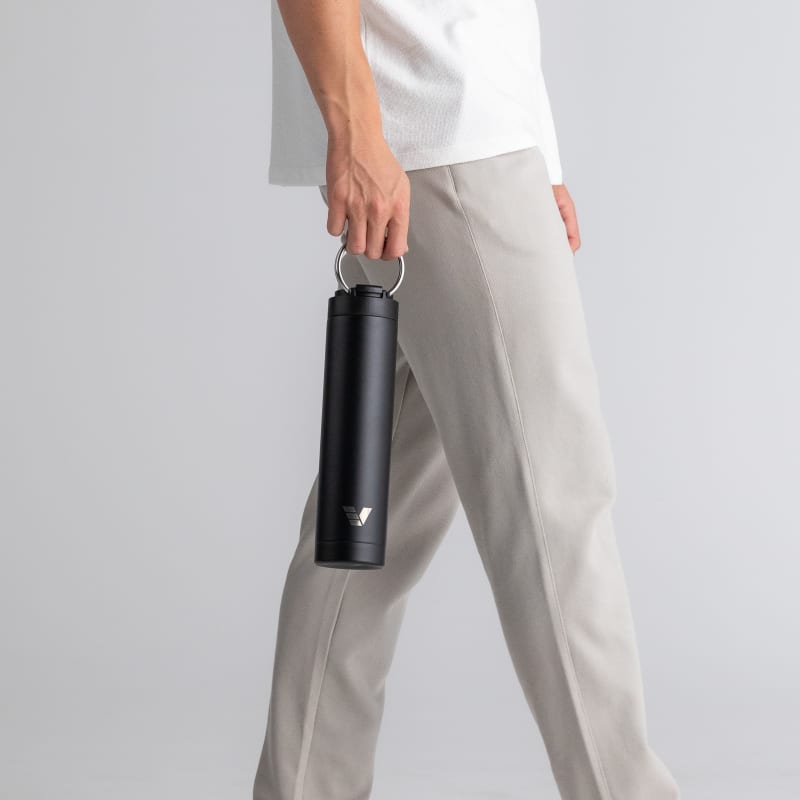 Male with an Ever Vessel Super Maxi Black Sand stainless steel water bottle, holding with the integrated handle