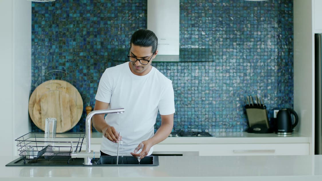 Person washing up Ever Vessel products and placing them onto a dish drying rack
