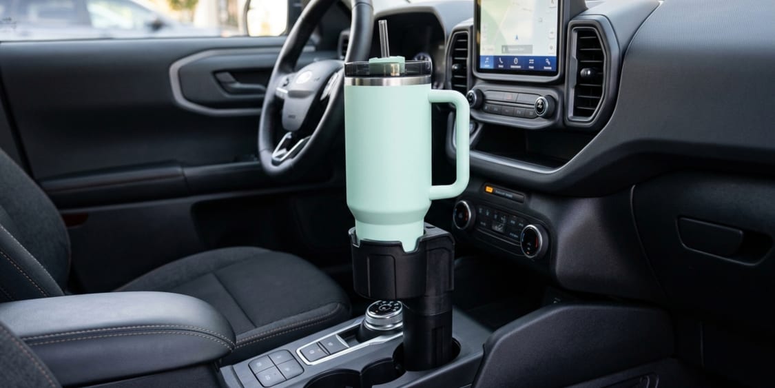 Car cup holder adapter with a light green tumbler inside