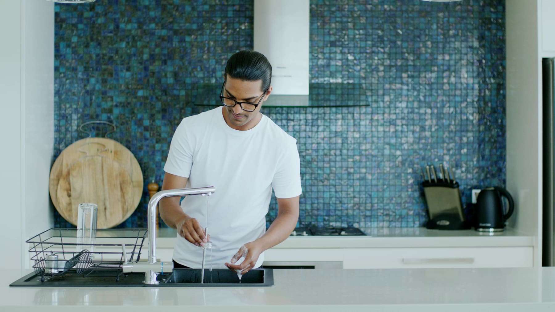 Person washing up Ever Vessel products and placing them onto a dish drying rack
