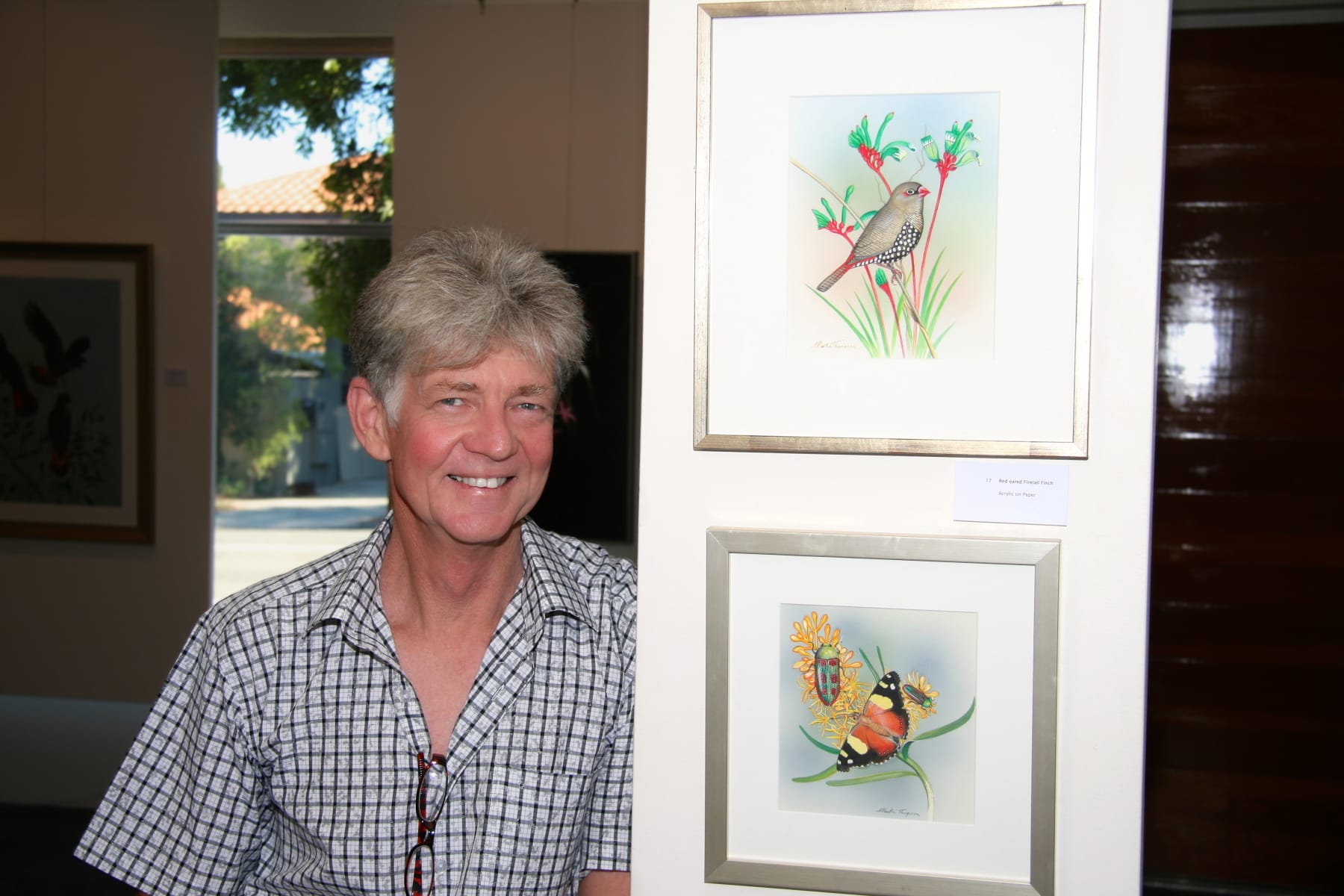 Picture of artist Martin Thompson at an Exhibition standing next to his art